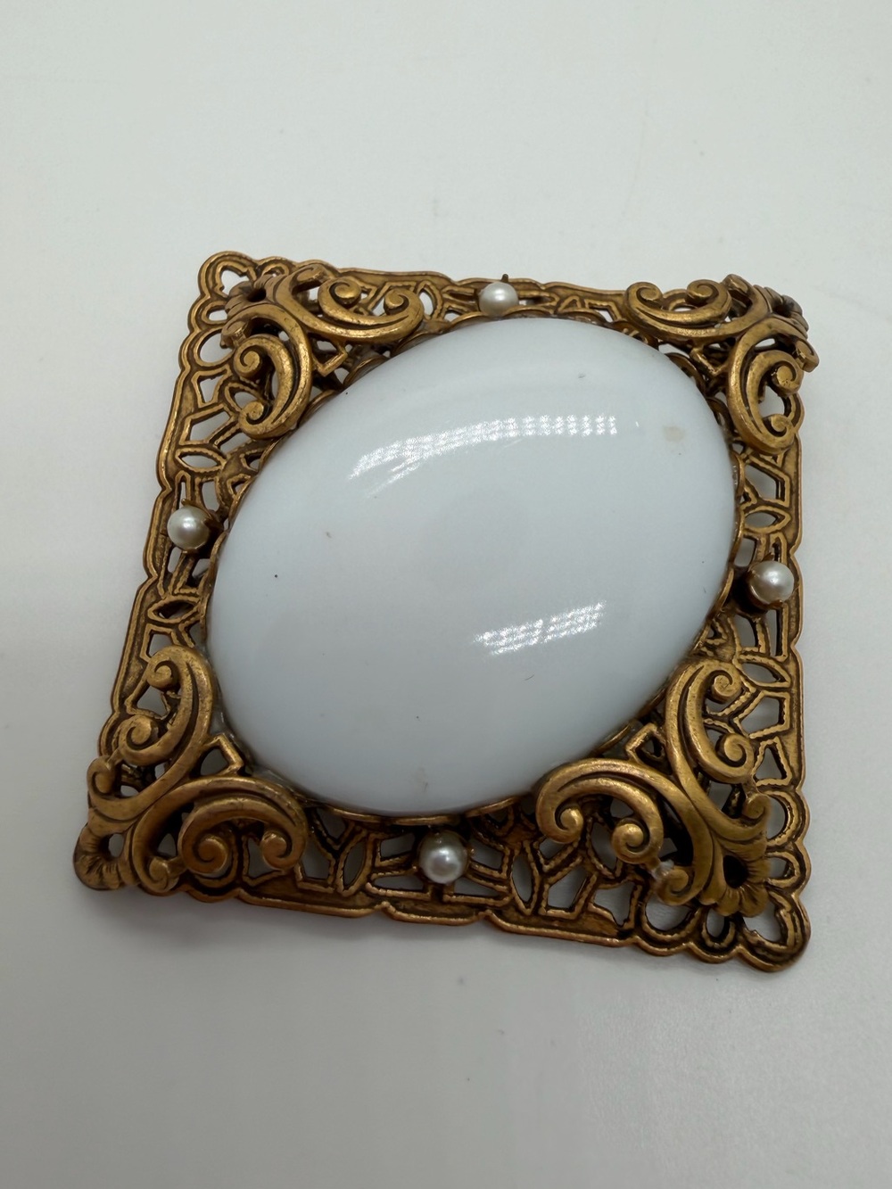 Victorian style filigree gold tone milk glass brooch